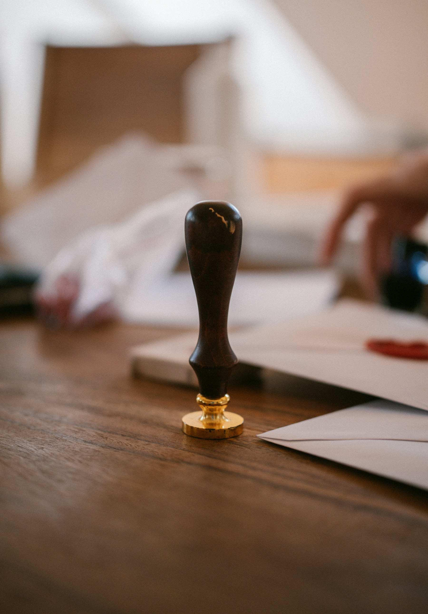 A wax seal stamp and envelopes on a desk